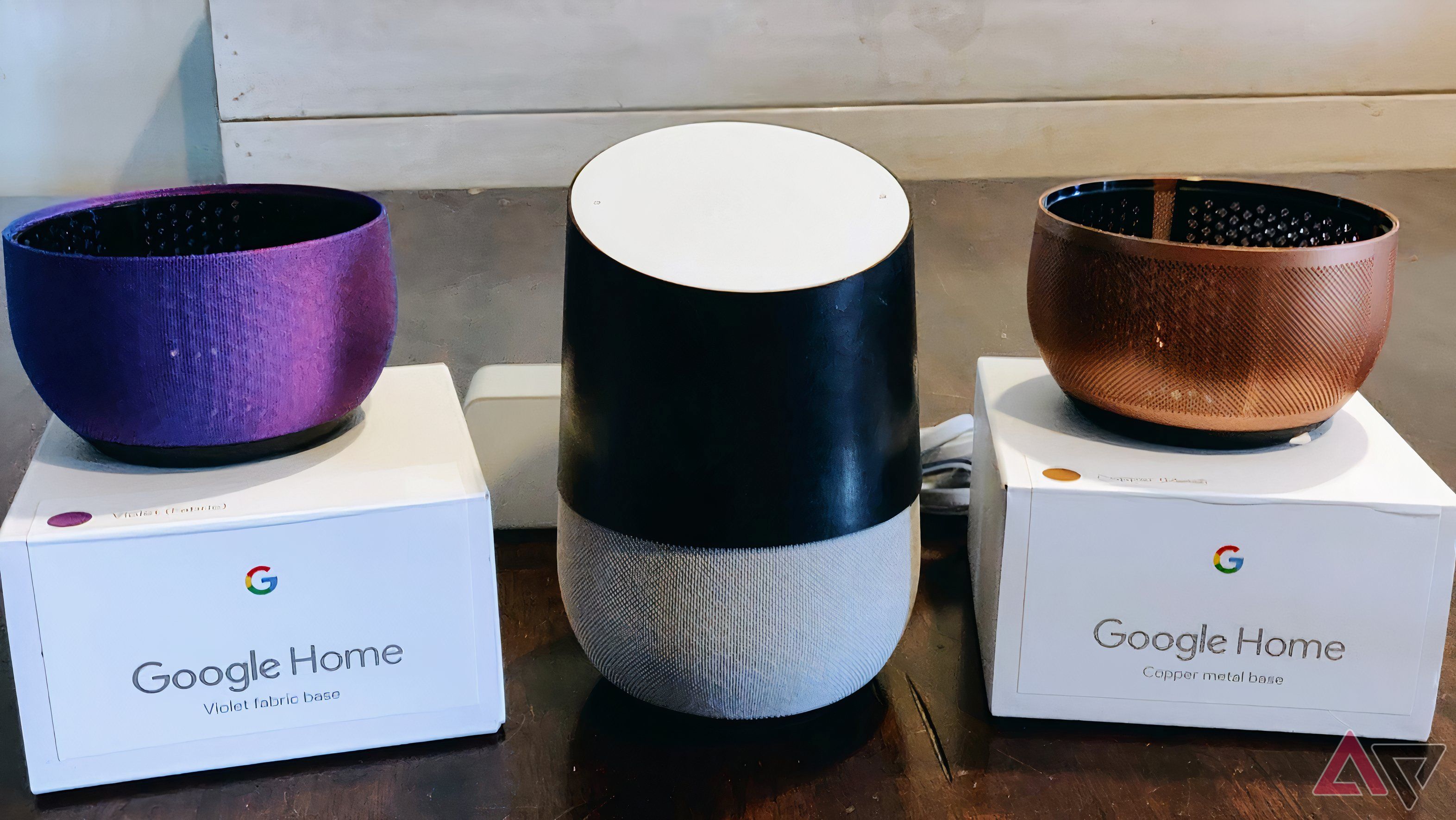 Google Home with black leather wrap and two speaker grills sitting on a table