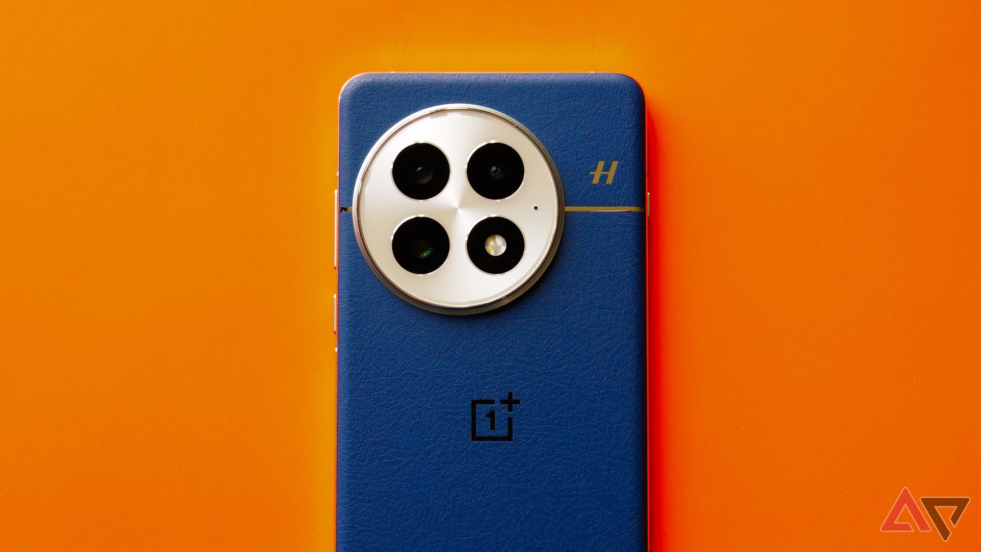 The OnePlus 13 on an orange background with the camera facing out.