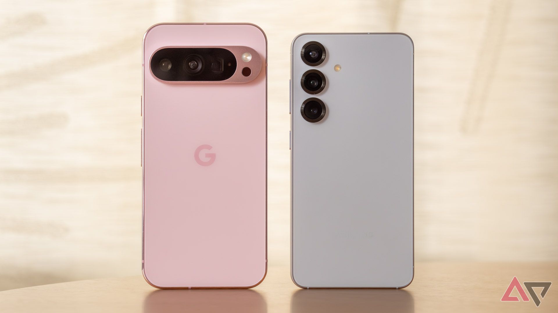 A pink Pixel 9 Pro standing next to a blue Samsung Galaxy S25