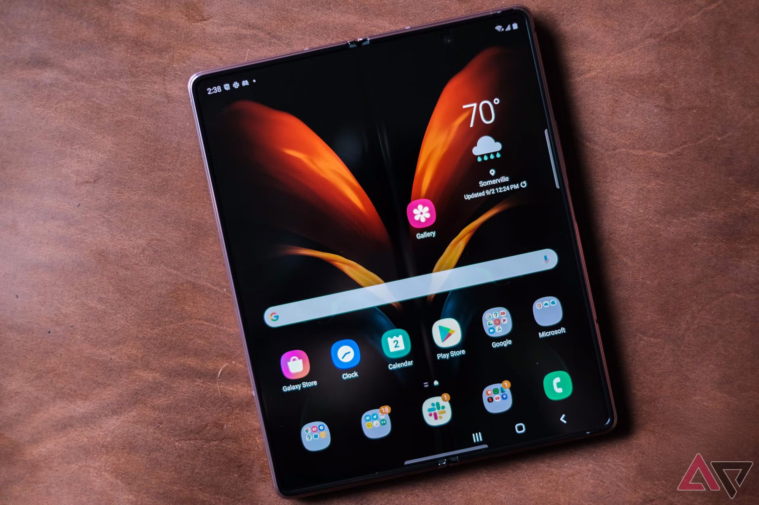 a samsung galaxy z fold 2 phone unfolded on a leather surface