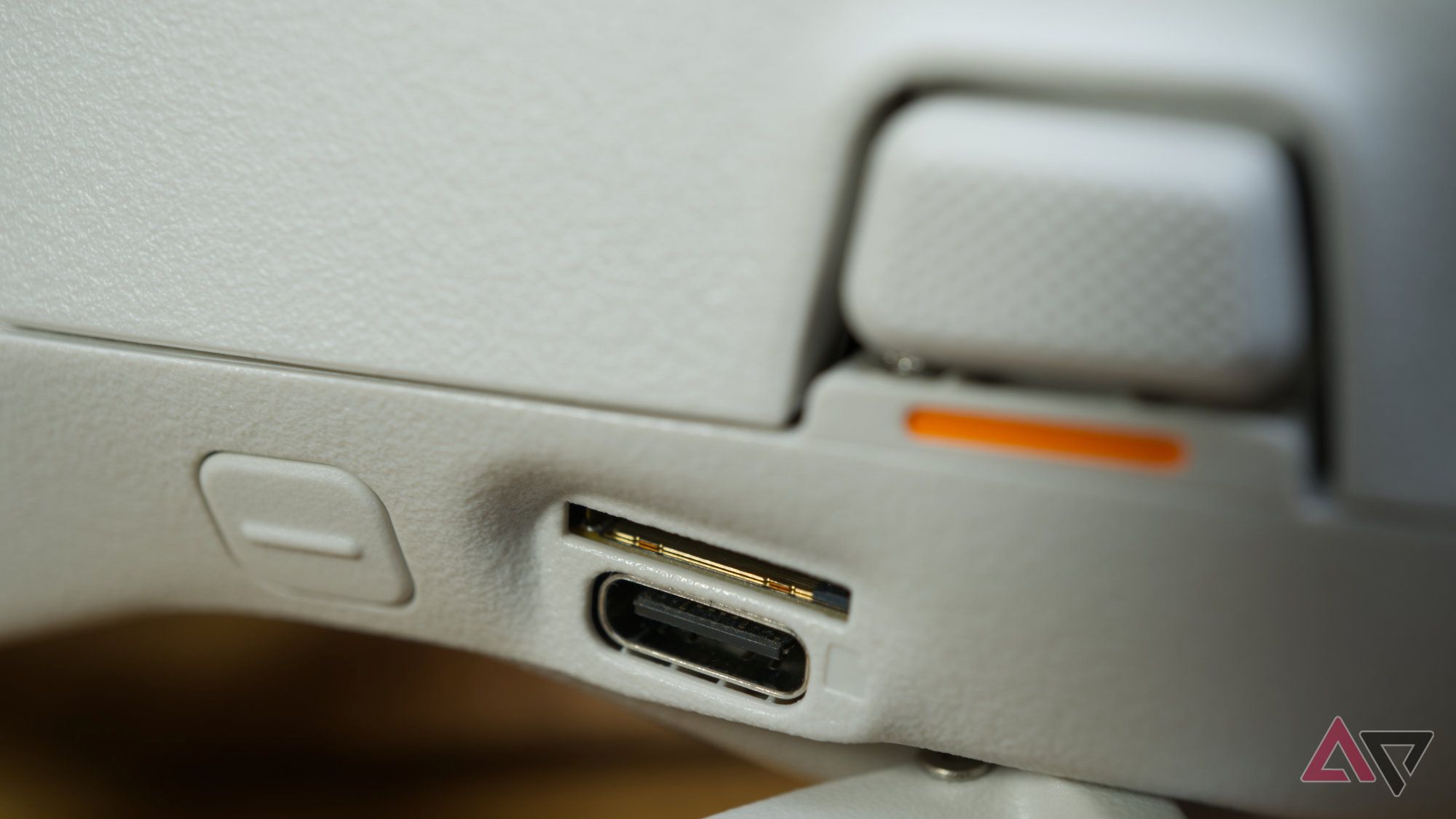 Close up of the DJI Flip aimed at the mode select button, USB-C port, and microSD memory card slot