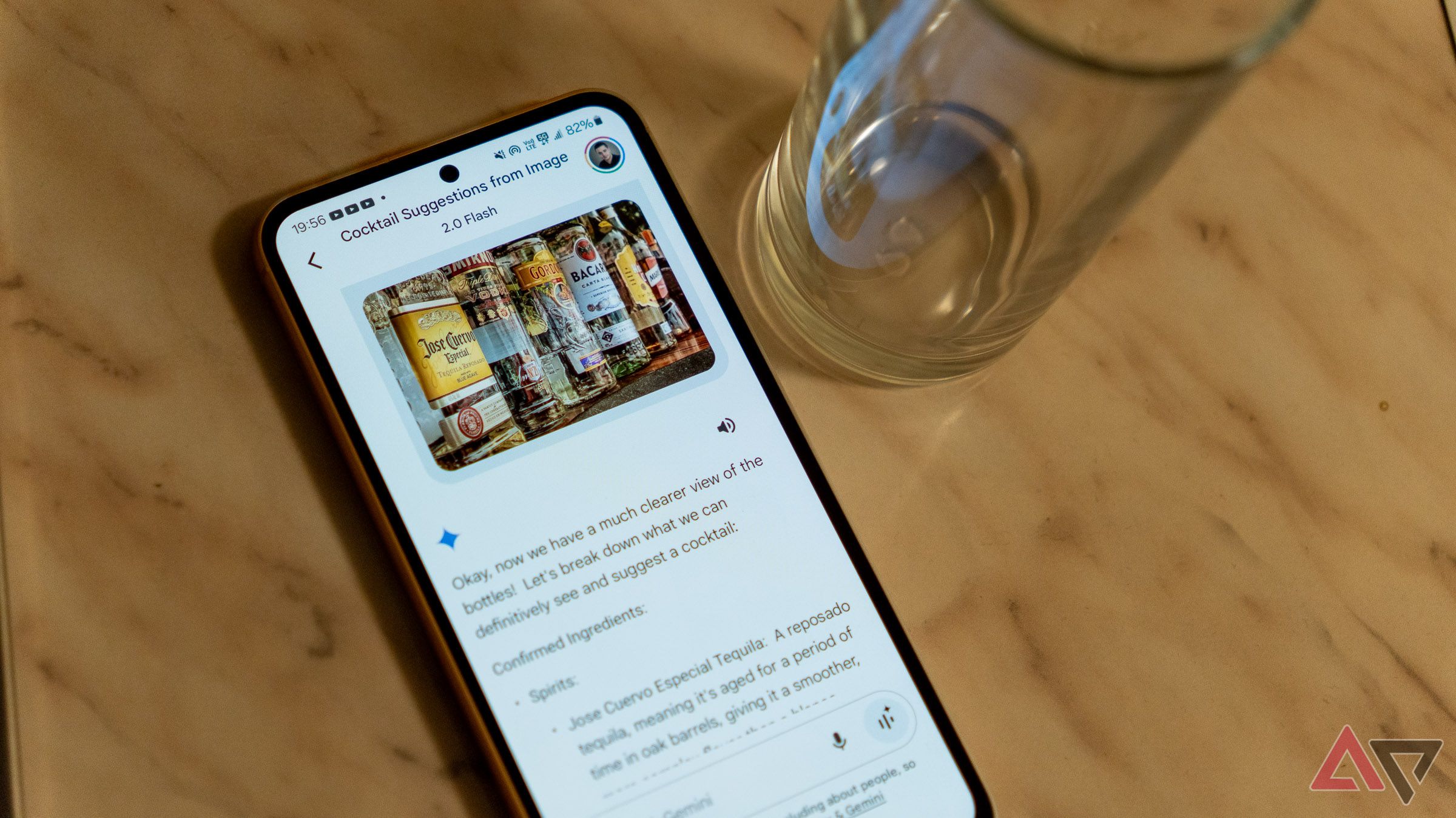 a samsung galaxy phone on a countertop next to a glass with google gemini app opened