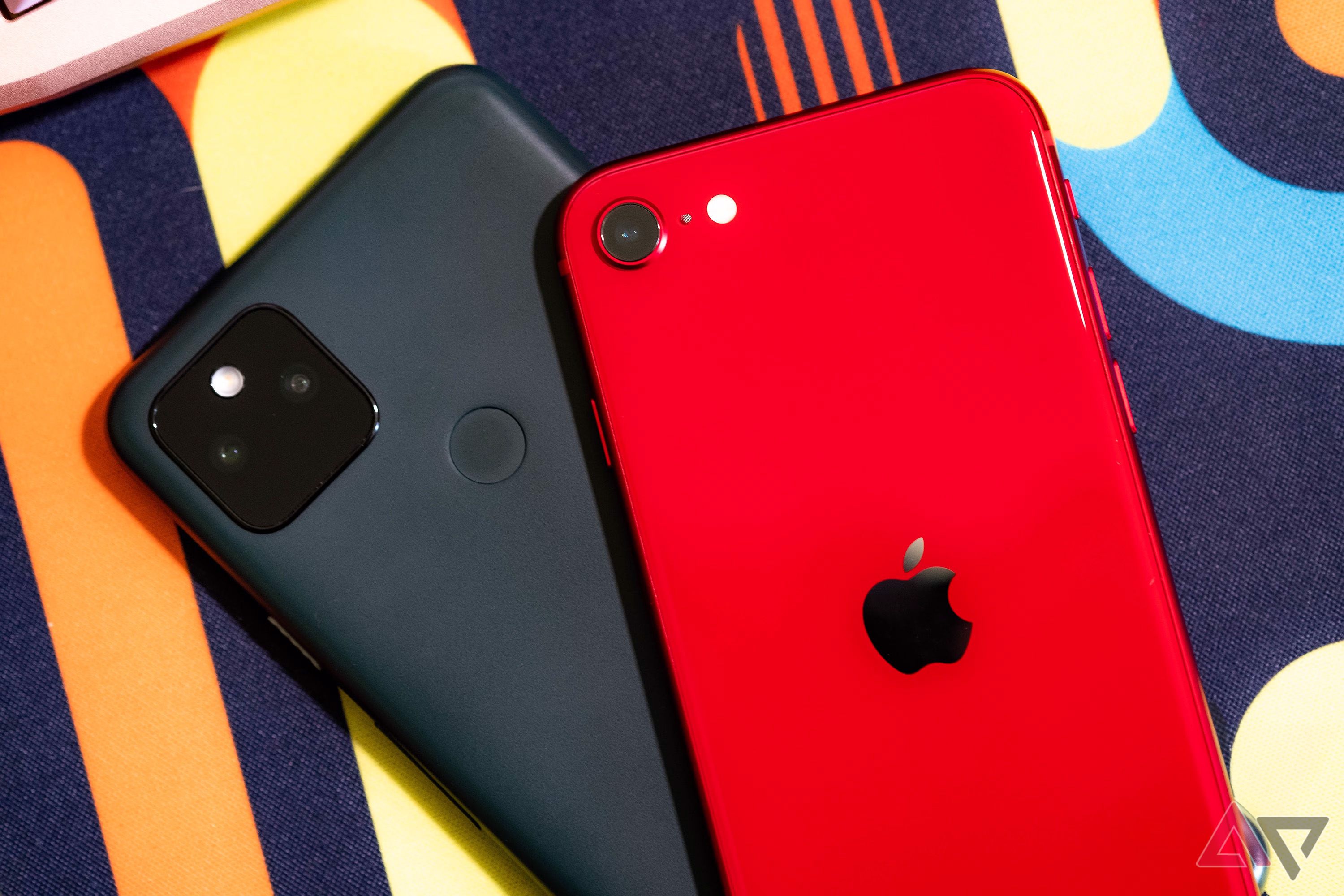 a red iphone se 2022 over black pixel 5a phone