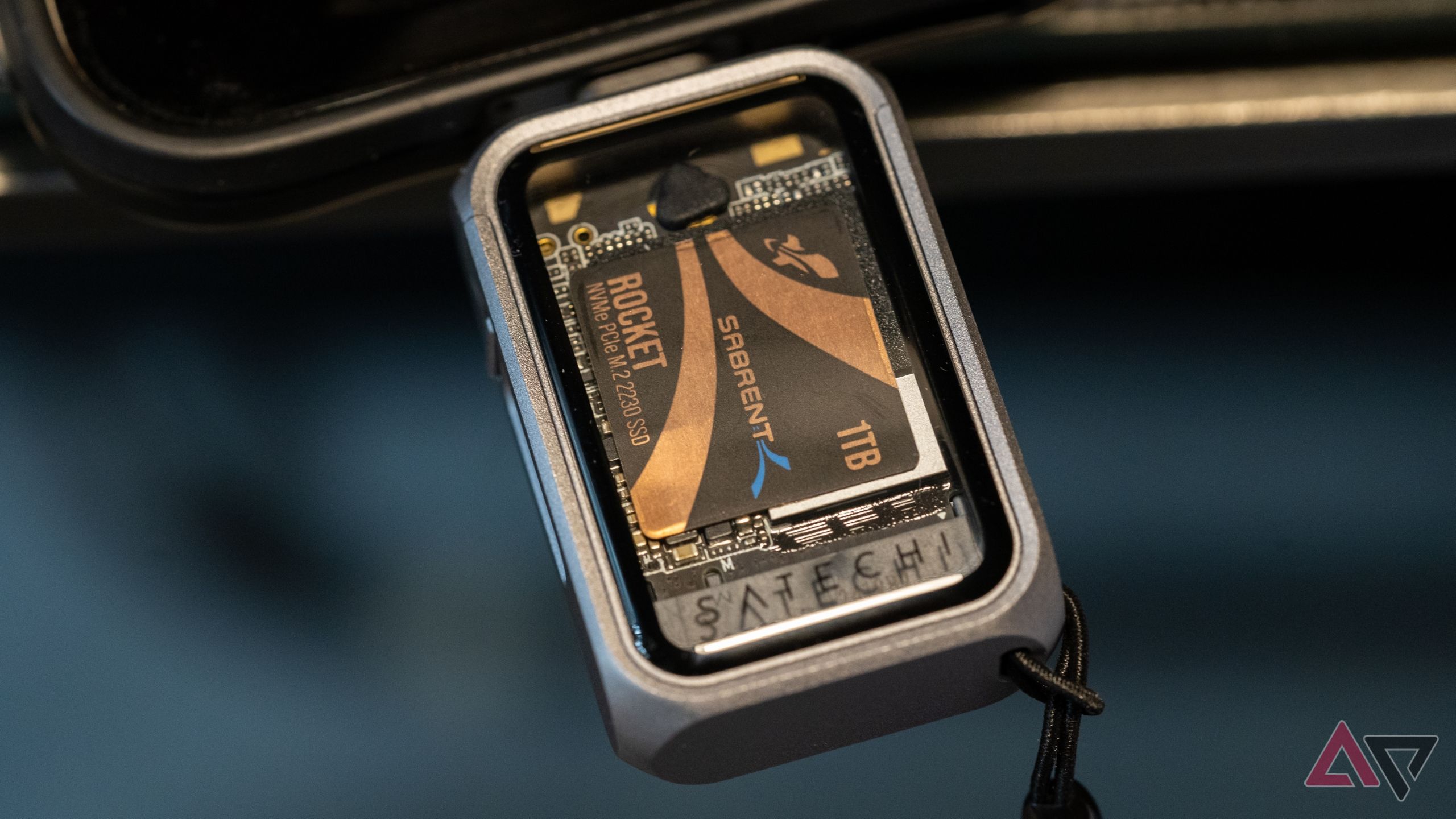 Satechi SSD Enclosure plugged into a device against a blurry blue background