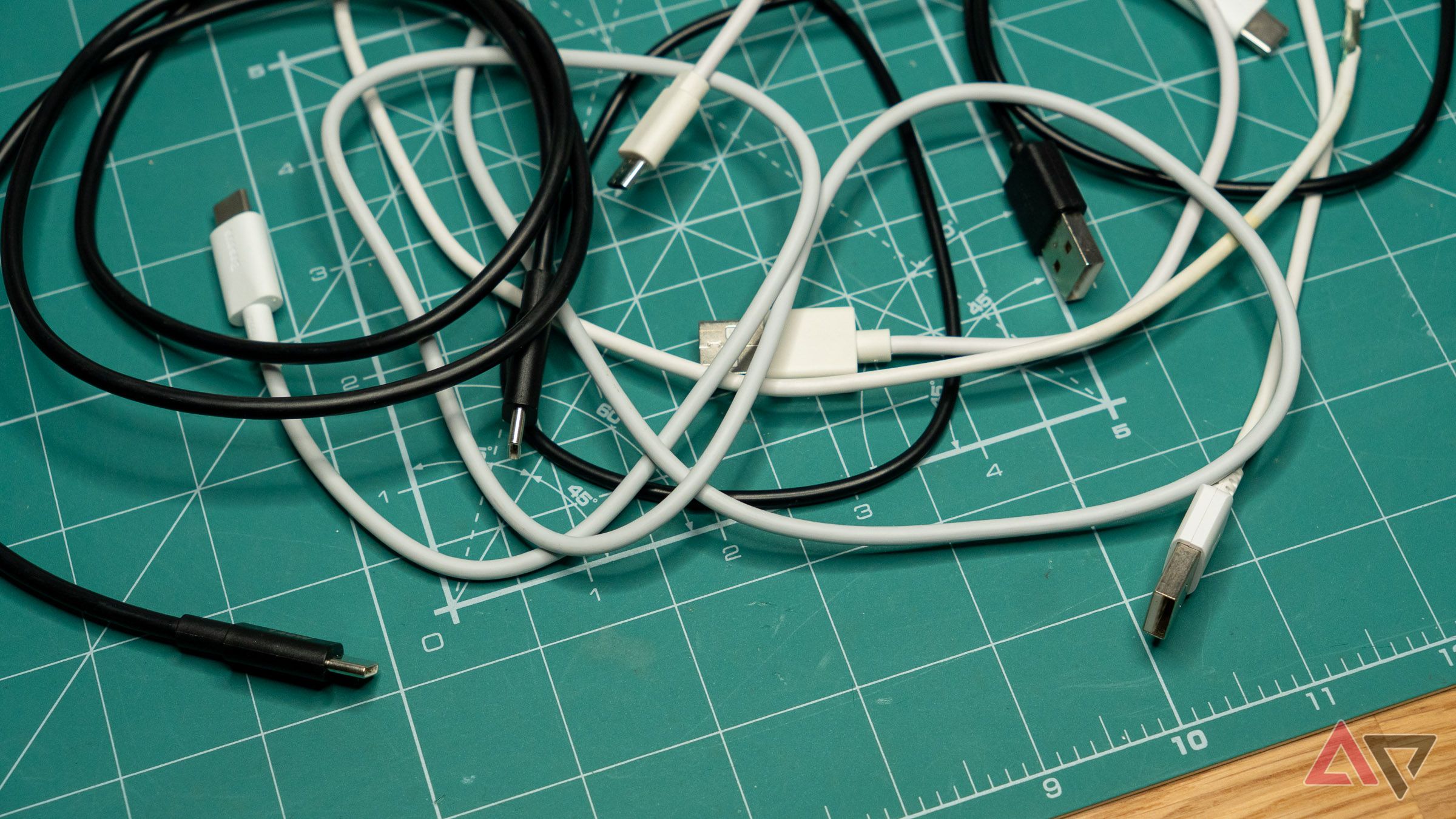 black and white USB cables scattered on a green mat