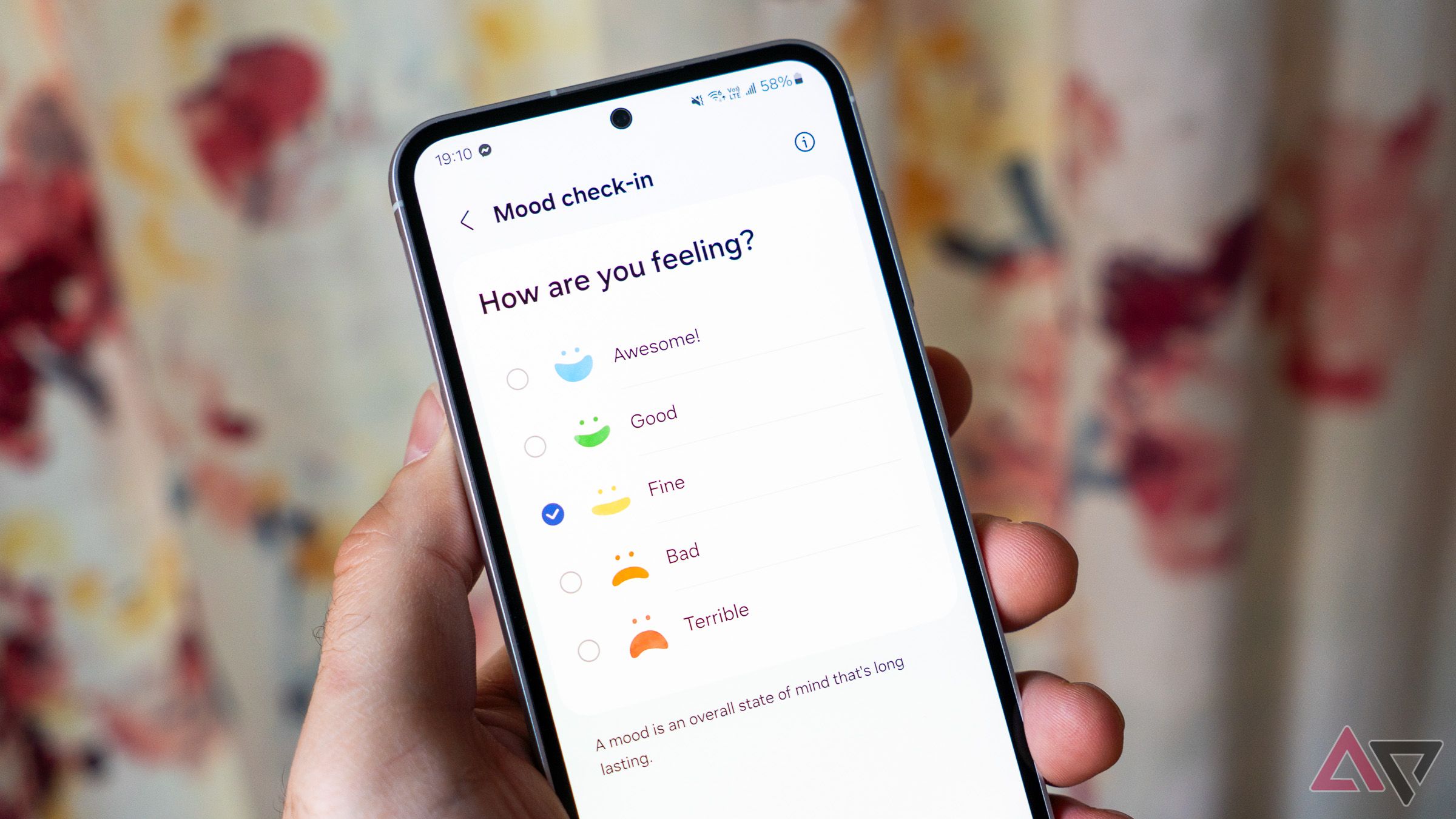 a phone in hand displaying a mood check screen 