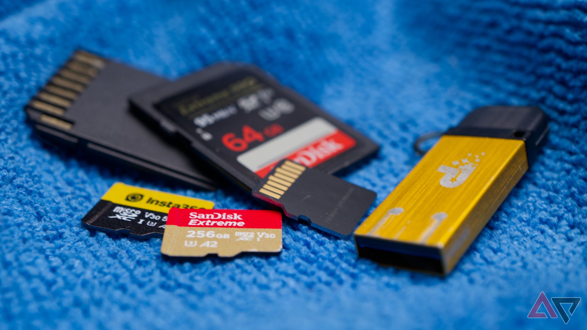 A small pile of memory cards and a USB drive on a blue cloth