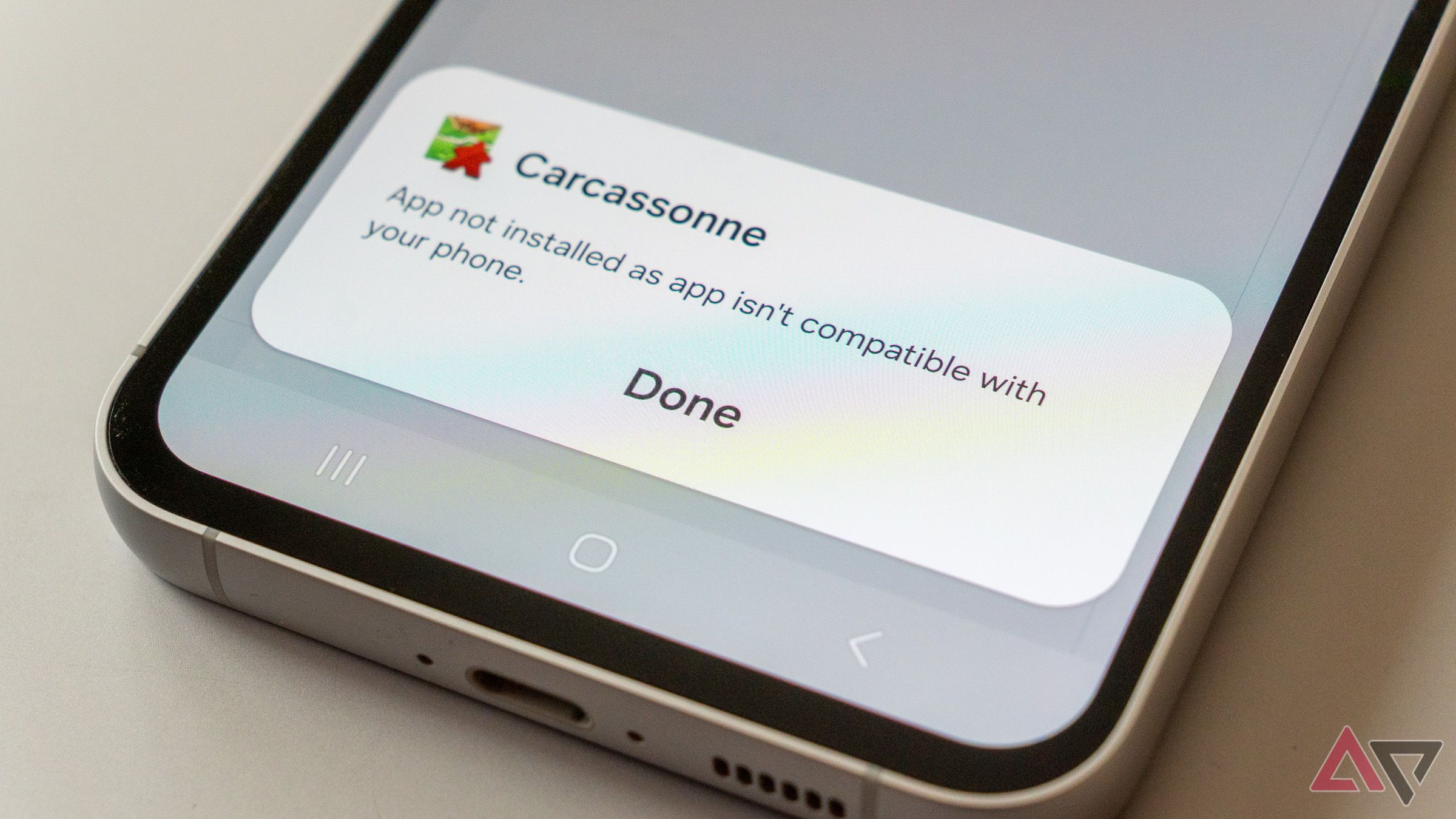 a close-up of a phone displaying a message saying that an app isn't compatible with the phone