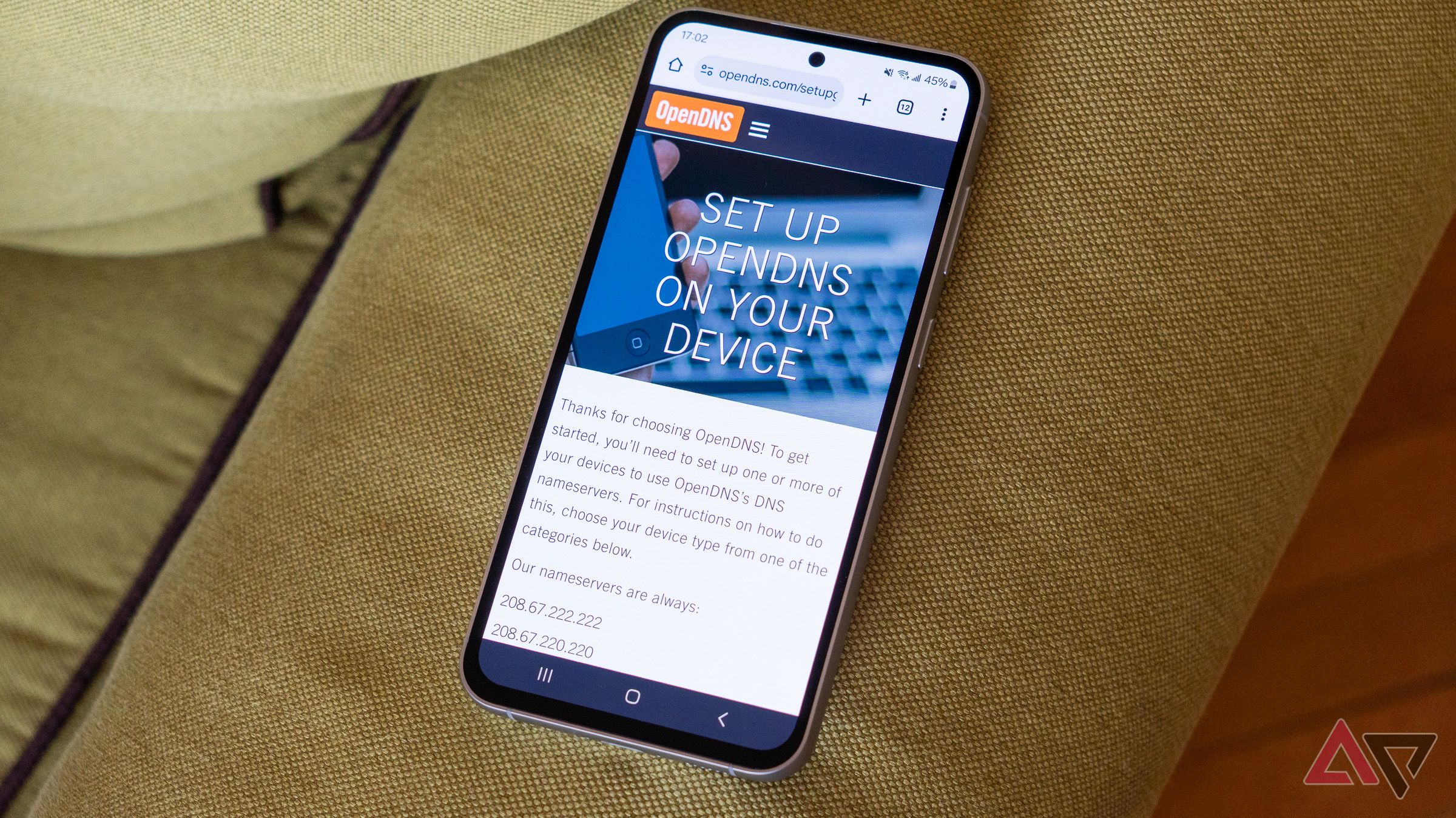 a phone on a green couch displaying the openDNS website 