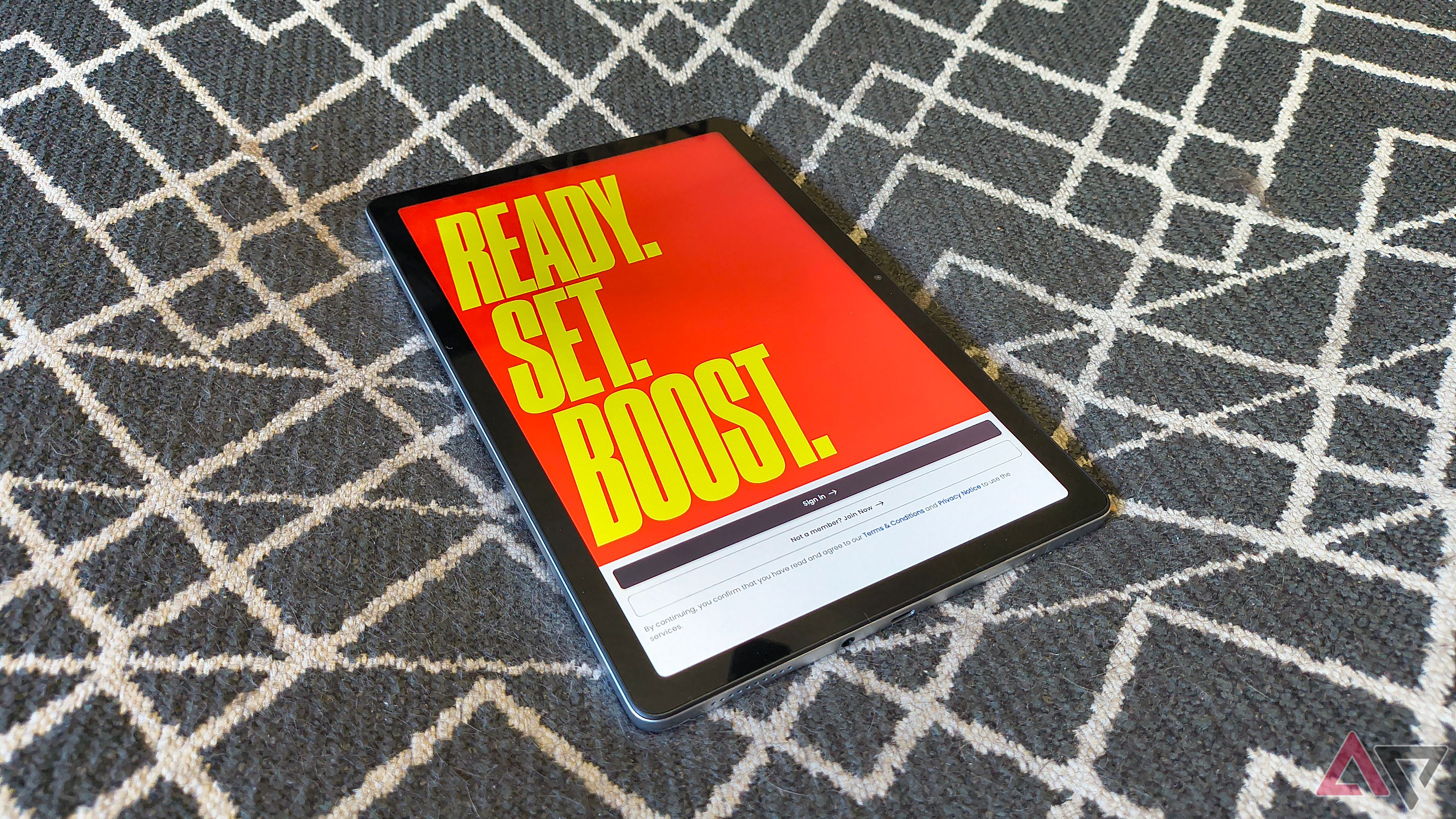 A Boost Celero5G TAB sitting face up on a black background with white lines with the Boost Mobile app open
