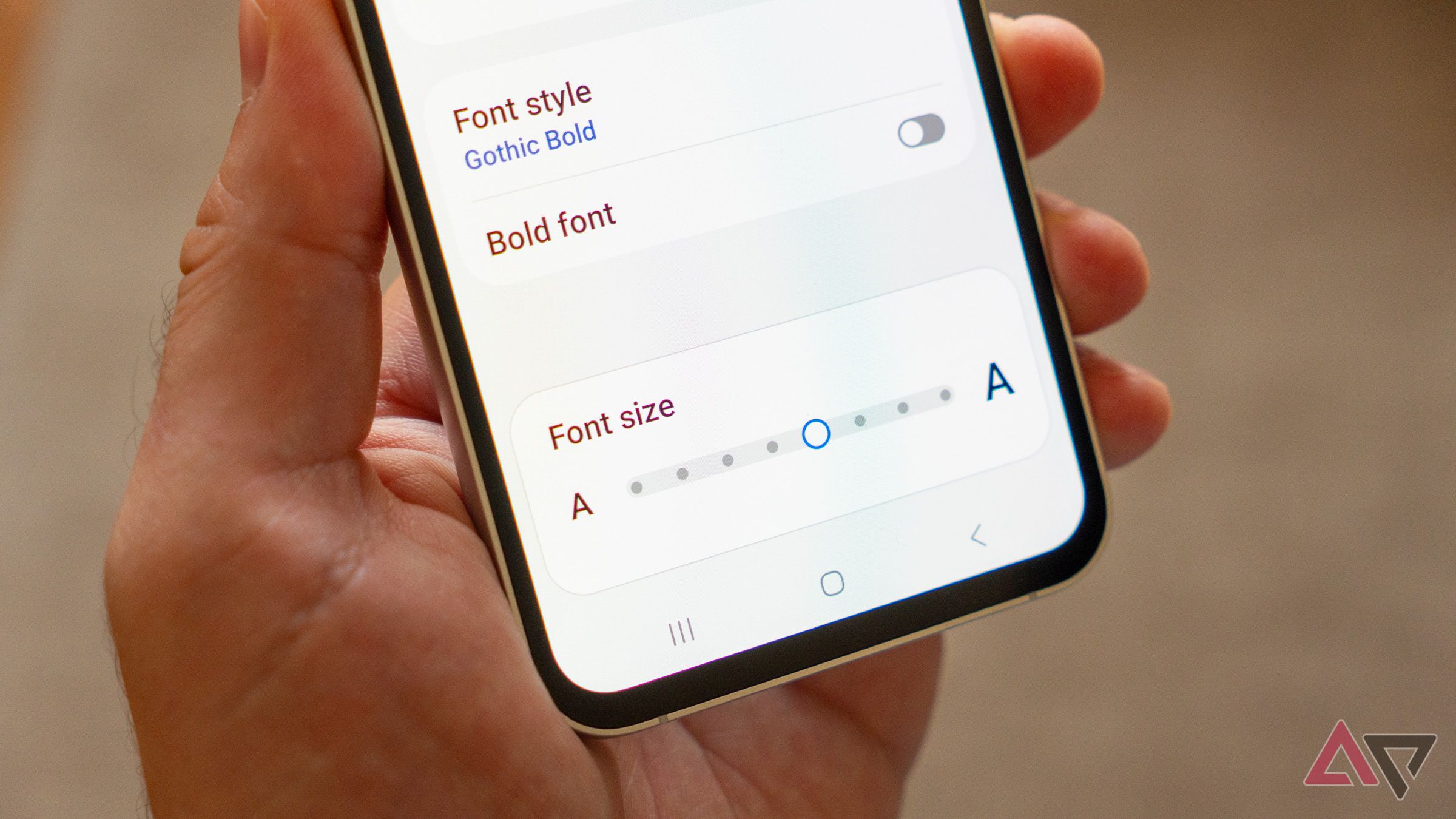 an android phone in hand displaying the font size settings screen