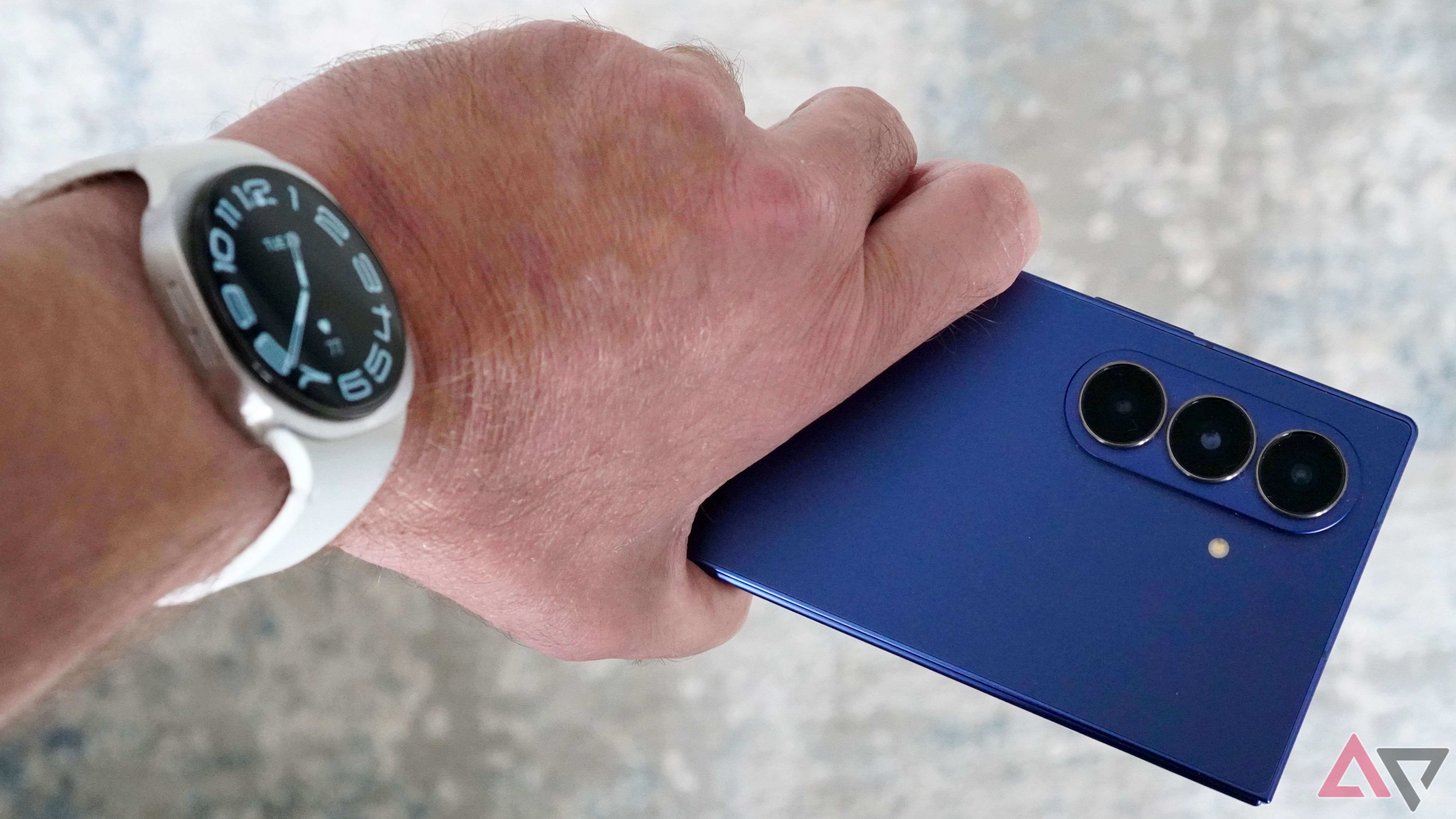 A wearing a Samsung Galaxy 8 watch and holding a Galaxy Z Fold 7 7 7 7 7 7 7 7 7 7 7 7 7 7 7 7 7 7 7 7 7 7 7 7 7 7 7 7 7 7 7 7 7 7 7 7 7 7 7 7 7 7 7 7 7 7 7 7 7 7 7 7 7 7 7 7 7 7 7 7 7 7 7 7 7 7 7 7 7 7 7 7 7 7 7 7 7 7 7 7 7 7 7 7 7 7 7 7 7 7 7 7 7 7 7 7 7 7 7 7 7 7 7 7 7 7 7 7 7 7 7 7 7 7 7 7 7 7 7 7