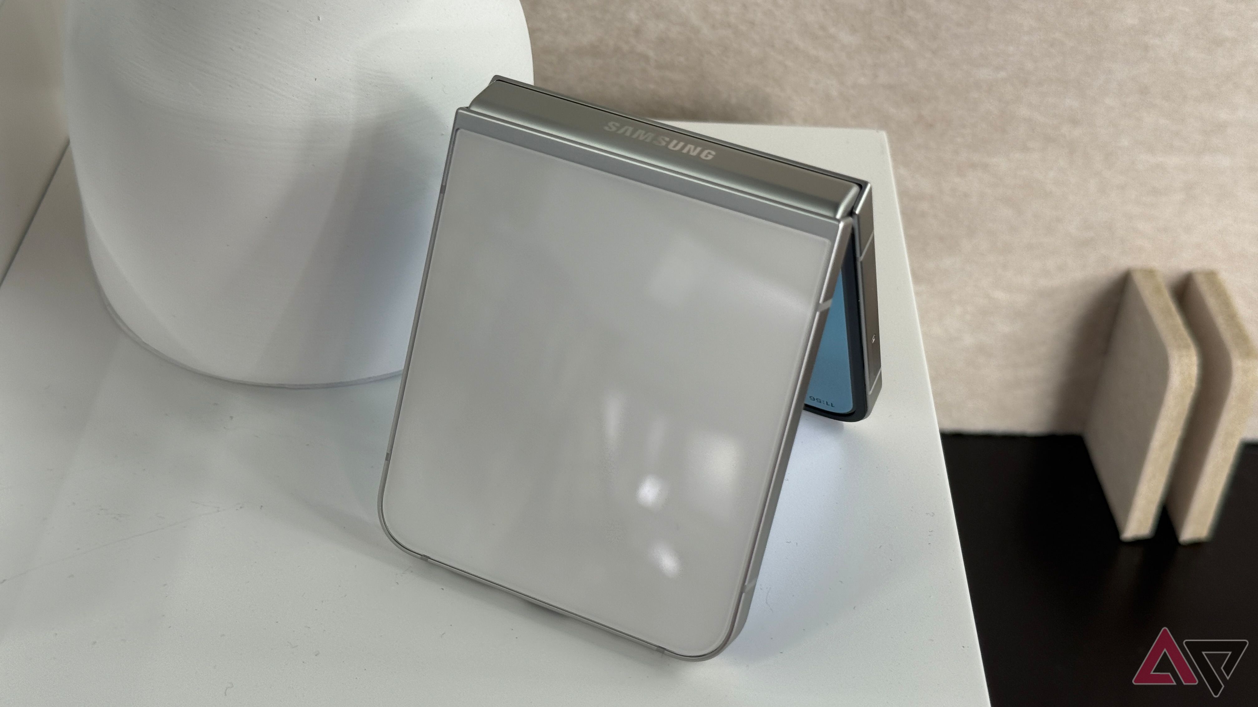 Samsung Galaxy Z Flip 7 FE in white on a tablet next to a lamp