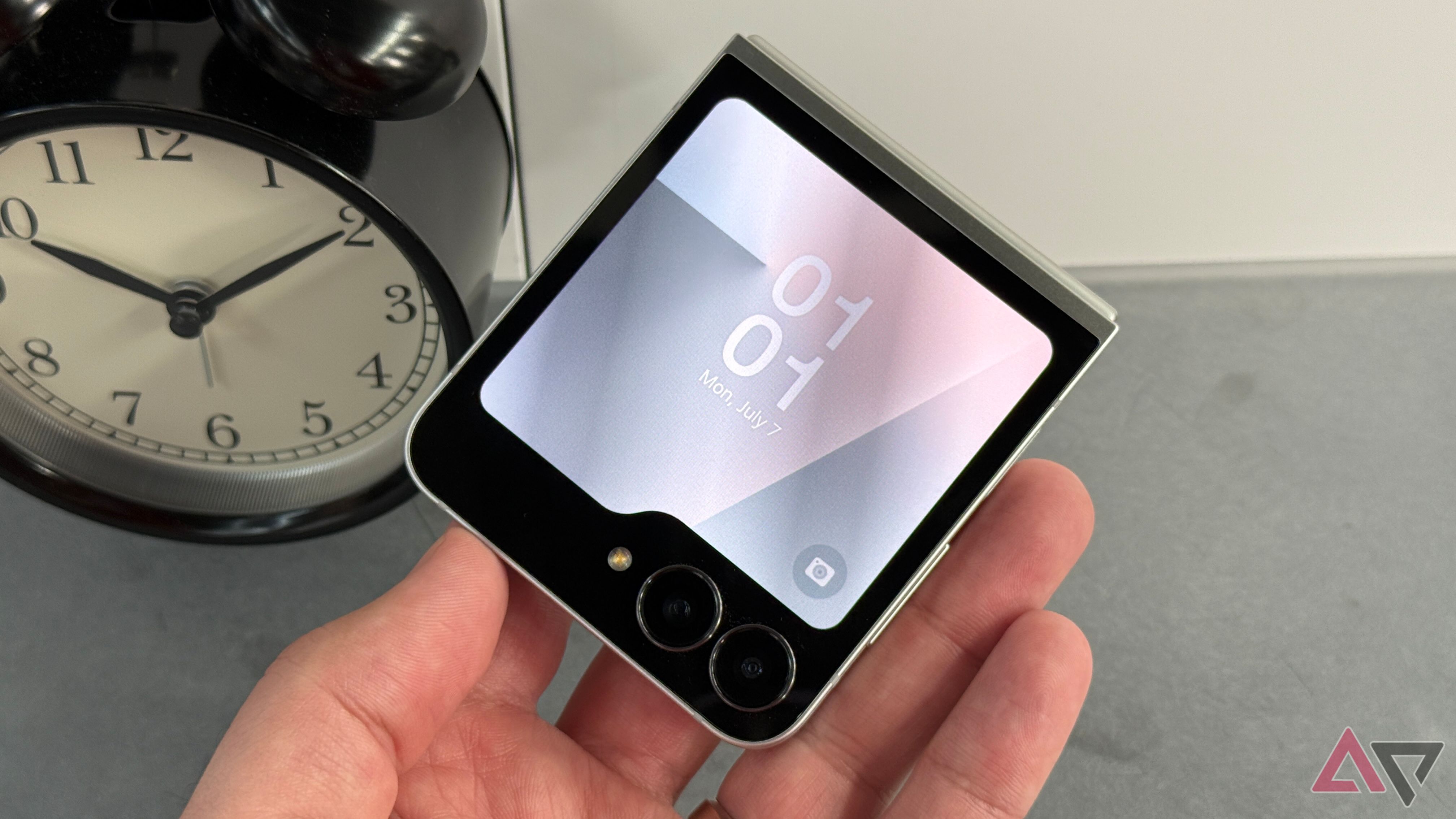 Samsung Galaxy Z Flip 7 FE held up against a clock