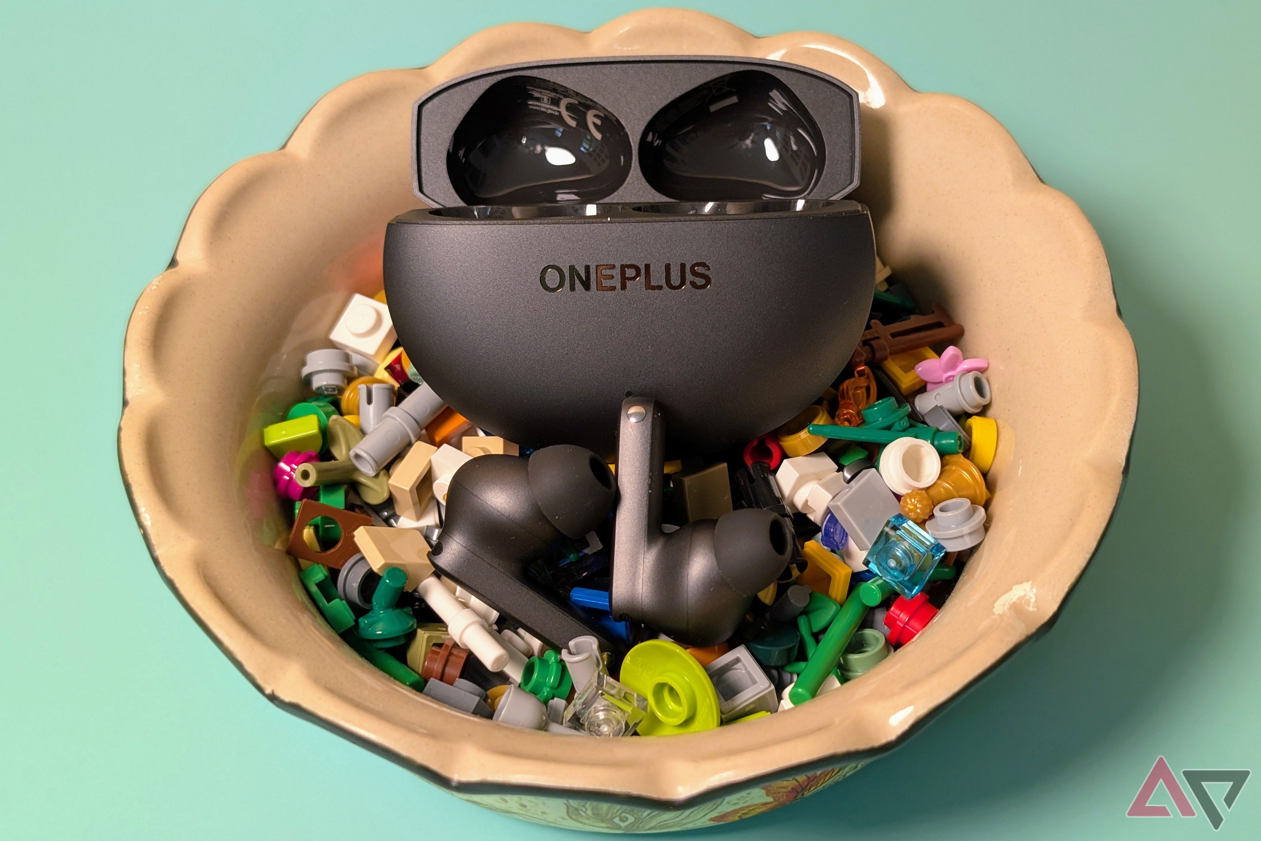 OnePlus Buds 4 in a clay bowl with lego pieces