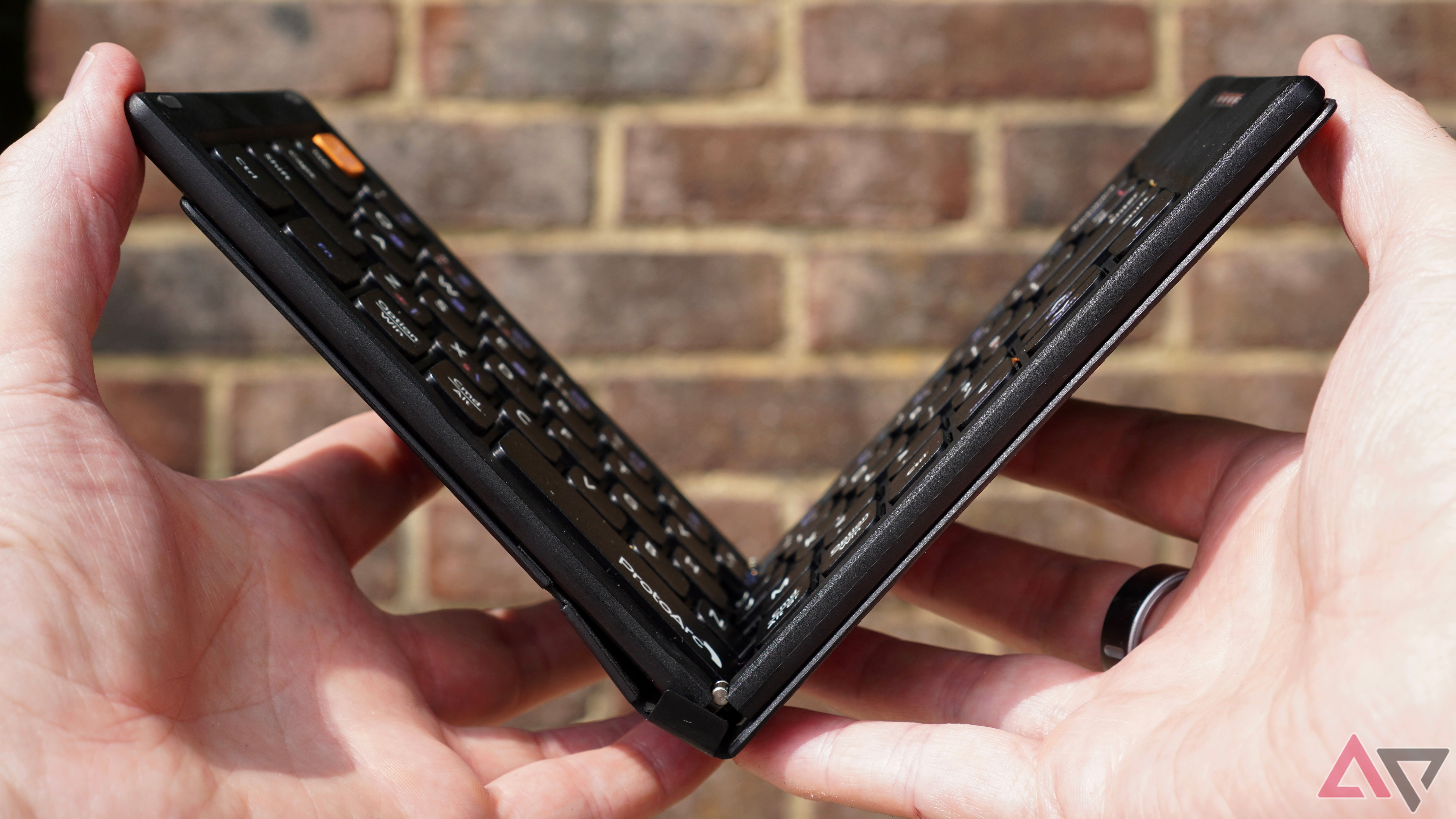 Uma pessoa que abre o teclado dobrável Protoarc XK04