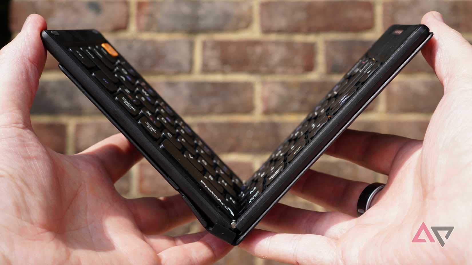 A person opening the ProtoArc XK04 folding keyboard