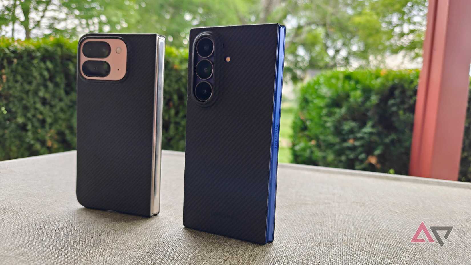 Samsung Galaxy Z Fold 7 and Google Pixel 9 Pro Fold partially open on a table outside